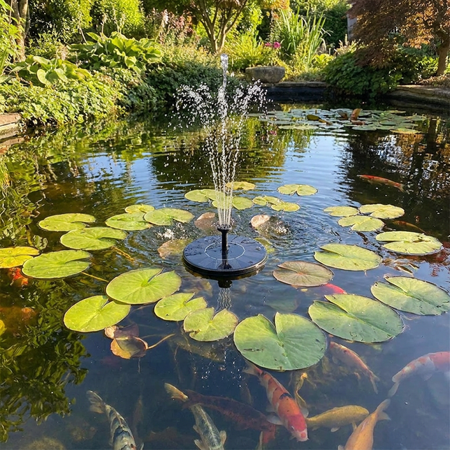 Solar fountain in garden pond with lily pads