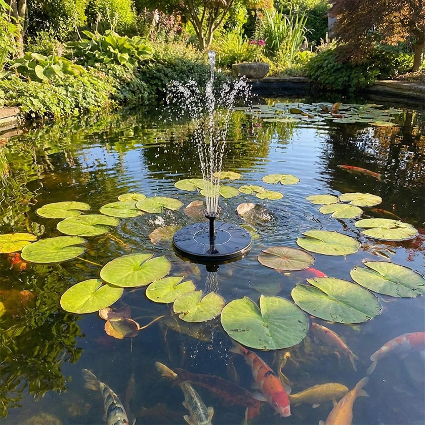 Solar fountain in garden pond with lily pads